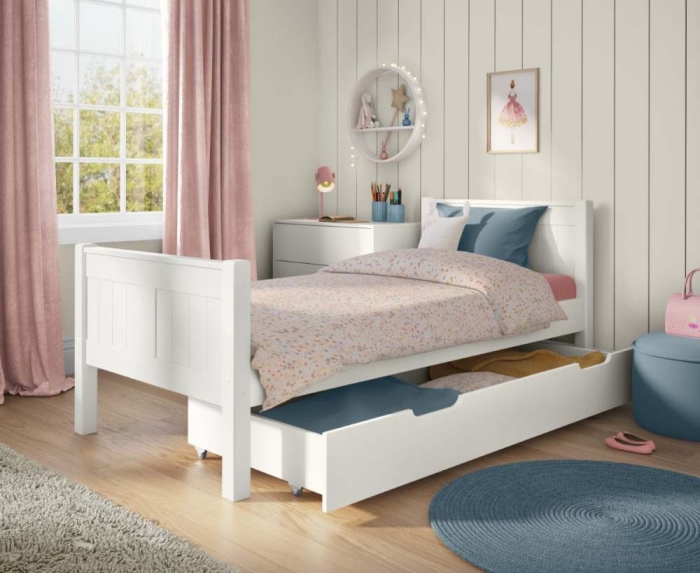 Bring spring vibes into your child's bedroom with a timeless white bed styled with soft tones of pink and blue