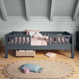 Closer front view of Arven blue Junior bed with safety guard rails styled with soft pink bedding in a Nordic style bedroom with tongue and groove soft blue painted walls.