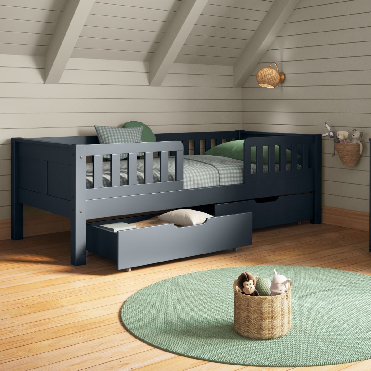 Cloaser view of Arven blue Junior bed with safety guards and a pair of drawers styled with gingham green and white bedding in an organised child's bedroom with slanted ceiling and tongue and groove wall panelling.