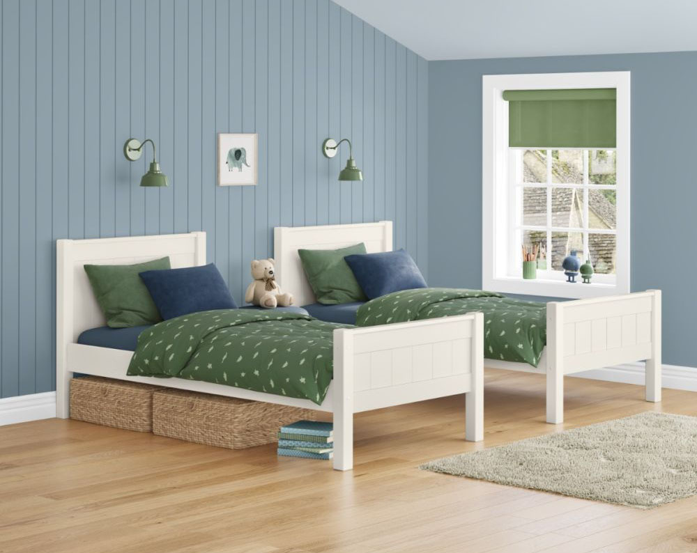 2 white painted single beds with tongue and groove details in the headboards and footboards in a child's room